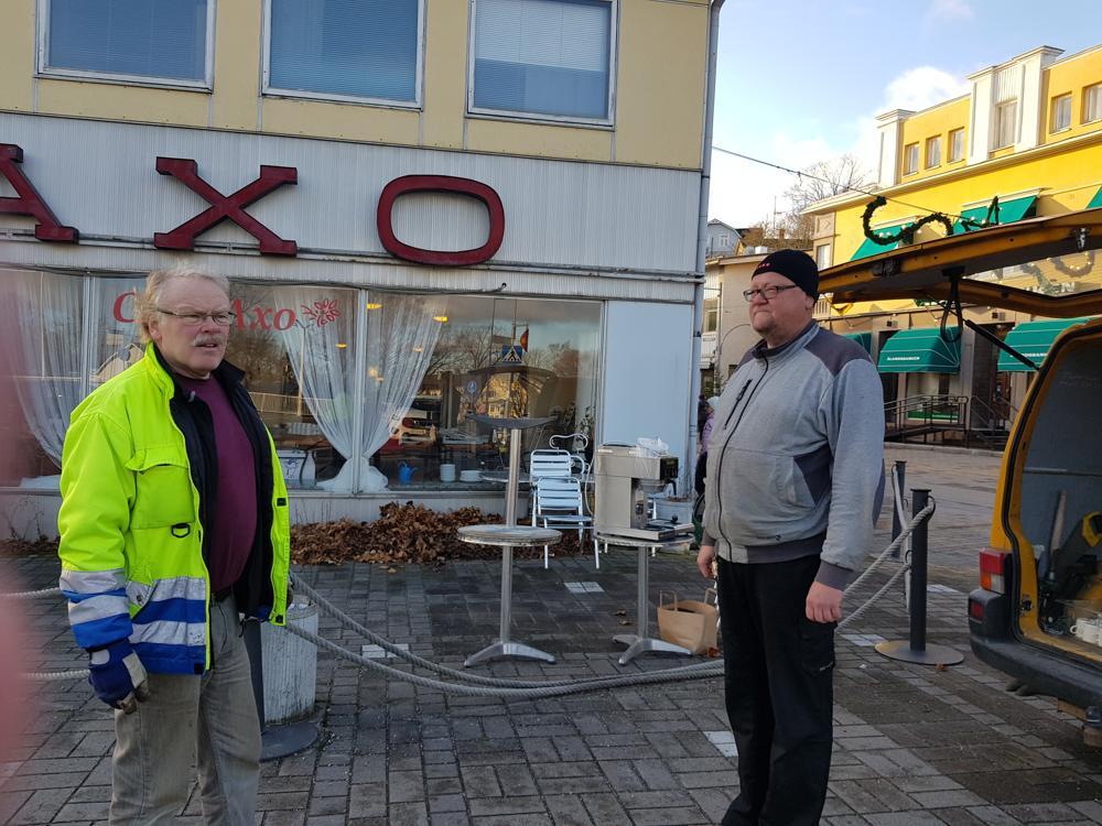 Två män utanför stängt café