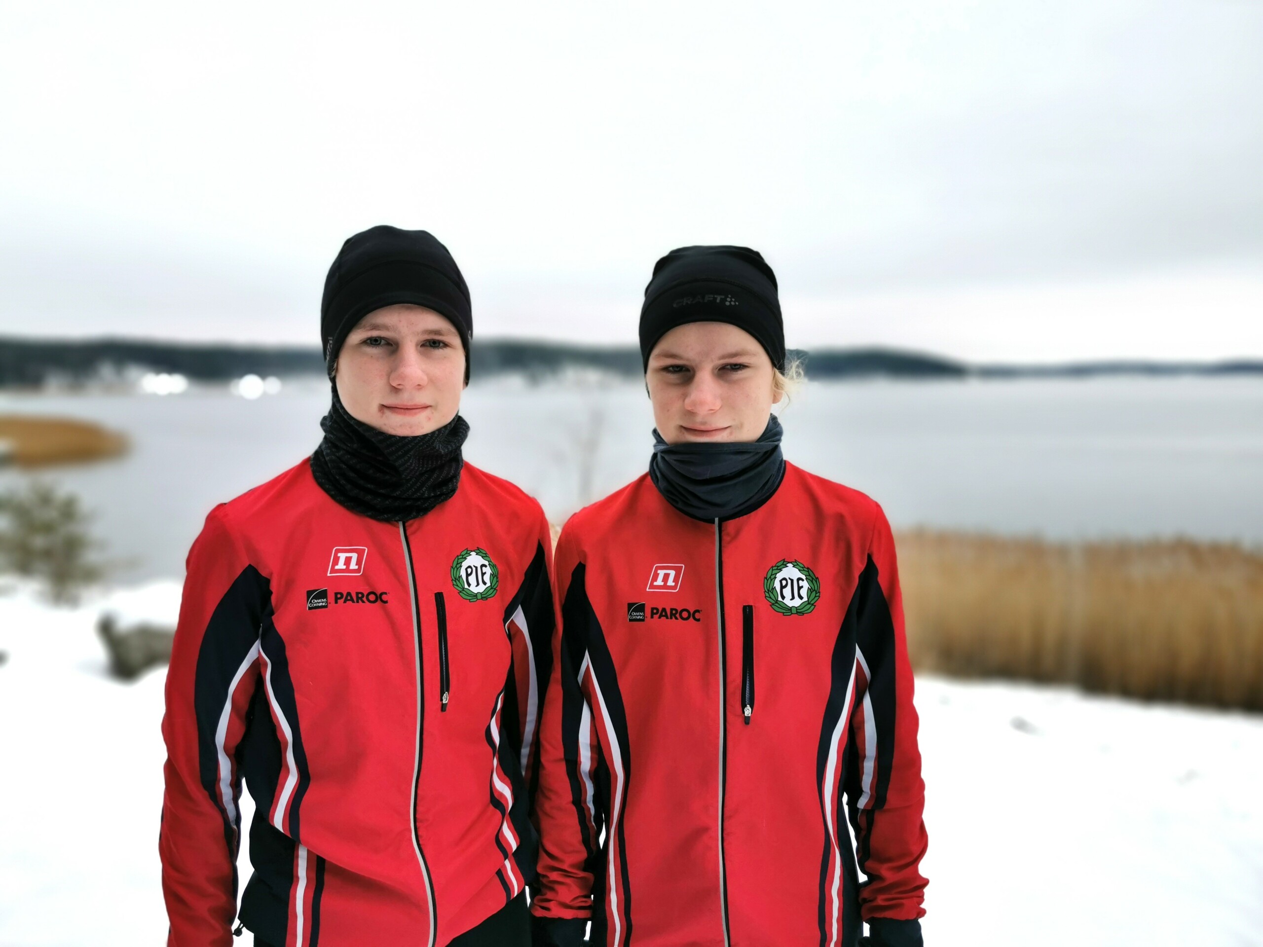 Två pojkar ute på vintern framför havet.