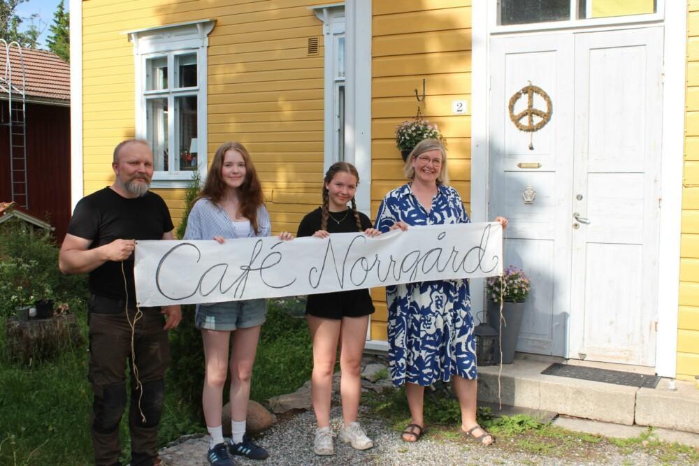 Fyra personer som håller i en banderoll där det står "Café Norrgård".